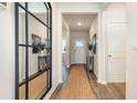Bright entryway with wood-look floors and modern decor that leads to the home's main living area at 3562 Ashridge Way, Conway, SC 29526