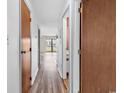 Bright hallway with wood-look flooring leading to a sliding glass door and balcony at 3700 Golf Colony Lane # 25G, Little River, SC 29566