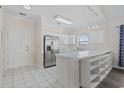 Bright kitchen features white cabinets, tiled floors, stainless steel refrigerator, and a convenient breakfast bar at 3983 Forsythia Ct. # 301, Myrtle Beach, SC 29588