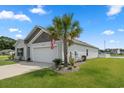 Well-maintained single-story home featuring a manicured lawn, a palm tree, and an attached two-car garage at 568 Mossbank Loop, Longs, SC 29568