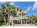 Charming raised beach house featuring a covered porch, manicured yard, and ample parking underneath at 58 Fathom Ln., Murrells Inlet, SC 29576