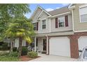 Exterior view of a charming townhome with a front porch, well-maintained lawn, and mature palm tree at 592 Riverward Dr. # 592, Myrtle Beach, SC 29588
