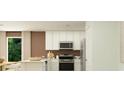 Modern kitchen with white cabinets, stainless steel appliances, and an island for extra workspace and dining at 6351 Swainson Street Sw, Ocean Isle Beach, NC 28469