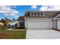 Single-Gathering home with a two-car garage, well-maintained lawn, and neutral-colored exterior at 7001 River Bridge Ct, Myrtle Beach, SC 29579