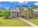 Inviting townhouse featuring a cozy front porch and vibrant, mature landscaping at 701 Wilshire Ln. # 0, Murrells Inlet, SC 29576