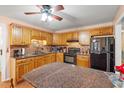Cozy kitchen with granite countertops, warm wood cabinets, and black appliances at 8506 Old Nichols Hwy., Nichols, SC 29581