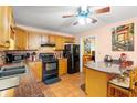 Cozy kitchen featuring tile flooring, warm wood cabinets, and modern black appliances at 8506 Old Nichols Hwy., Nichols, SC 29581