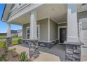 Welcoming covered porch with stone accents and a front door, inviting entry to this stylish home at 8761 Nw Nashville Dr., Calabash, NC 28467