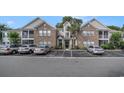 Condo featuring a brick facade, screened porches, and mature trees at 9 Pistachio Loop # D, Murrells Inlet, SC 29576