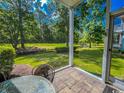 Relaxing screened-in patio offers serene views of the lush green surroundings and a tranquil creek at 1101 Peace Pipe Pl. # 104, Myrtle Beach, SC 29579