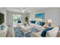 Bright living room with beach-themed decor, ceiling fan, and sliding glass doors to balcony at 1200 5Th Ave. N # 1207, Surfside Beach, SC 29575