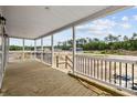 Relaxing outdoor porch with wooden floors, white railings, and posts showcasing scenic views of the surrounding property at 1321 Rabbit Ln., Conway, SC 29526