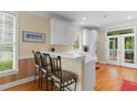 Bright kitchen featuring white cabinets, breakfast bar, and views to the outside porch at 141 Cayman Loop, Pawleys Island, SC 29585
