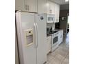 White kitchen appliances including refrigerator, microwave, and oven, with tile flooring at 1432 Seahouse Ct., Surfside Beach, SC 29575
