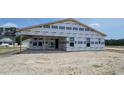Backyard view showcasing a home under construction with a patio and large windows at 1531 Breakwater Dr., Little River, SC 29566