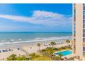 Gorgeous ocean view from the balcony with sandy beach, blue umbrellas, and palm trees at 161 Sea Watch Dr. # 601, Myrtle Beach, SC 29572