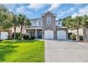 Charming home with a combination of stone and siding, complemented by lush palm trees and a two car garage at 1619 Eastover Ln., North Myrtle Beach, SC 29582
