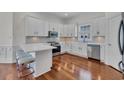 Modern kitchen featuring white cabinets, stainless steel appliances, and a breakfast bar with seating at 1619 Eastover Ln., North Myrtle Beach, SC 29582