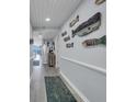 Hallway decorated with nautical-themed artwork leading to bright living area at 1625 S Ocean Blvd. # 211, North Myrtle Beach, SC 29582
