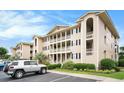 View of a condo building with a well-kept lawn and ample parking at 1900 Duffy St. # L4, North Myrtle Beach, SC 29582