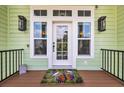 Inviting front door entrance with sidelights, decorative lights and a charming butterfly-themed doormat at 191 Grackle Ln., Pawleys Island, SC 29585