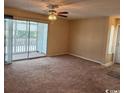 Spacious living room featuring a ceiling fan and access to a screened porch at 1980 Bent Grass Dr. # F, Surfside Beach, SC 29575