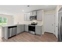 The kitchen offers stainless steel appliances, light countertops, light grey cabinets, and wood floor at 211 Pine Forest Dr., Conway, SC 29526