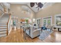 Bright living room features a soaring ceiling, hardwood floors, stairs and stylish neutral decor at 24 Jerry Ct., Pawleys Island, SC 29585