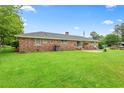 Expansive backyard featuring a brick exterior, a well-kept lawn, and a cozy patio area at 316 Oliver St., Marion, SC 29571