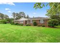 Inviting brick home with well-maintained lawn and landscaping beneath a bright blue sky with green trees at 316 Oliver St., Marion, SC 29571