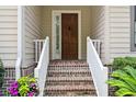 Close-up of the front door featuring brick stairs and white railings leading up to it at 346 Tuckers Rd. # A, Pawleys Island, SC 29585