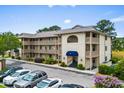 Condominium building featuring multiple stories, balconies, and well-manicured landscaping at 4101 Pinehurst Circle # Aa-3, Little River, SC 29566