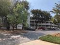 Exterior shot of a condo complex showing parking area, landscaping, and building facade at 415 Ocean Creek Dr. # 2372, Myrtle Beach, SC 29572