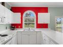 Bright kitchen featuring a stainless steel sink and bright red accent wall at 4673 Wild Iris Dr. # 21-201, Myrtle Beach, SC 29577
