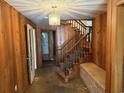 View of wood-paneled entryway featuring wood stairs, brick accents, and chandelier at 4909 Yaupon Circle, Myrtle Beach, SC 29575