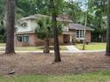 A two-story home featuring a brick facade, siding, and mature trees at 4909 Yaupon Circle, Myrtle Beach, SC 29575