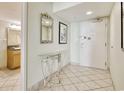 Bright condo entryway features tile flooring, mirrored table, artwork, and bathroom at 504 N Ocean Blvd. # 1106, Myrtle Beach, SC 29577