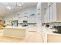Bright, white kitchen with stainless steel appliances, ample cabinet space, large island and stylish backsplash at 631 Rycola Circle, Surfside Beach, SC 29575