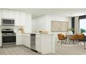 Bright, open kitchen with stainless appliances flows into a dining area with seating for six at 6362 Swainson Street Sw, Ocean Isle Beach, NC 28469