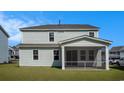 The view of the spacious backyard and the screened back porch on a light blue two story home at 727 Rupert Dr, Conway, SC 29526