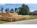 View of lumber piles at a residential construction site surrounded by wooded area at 800 Stone Pine Ct., Loris, SC 29569