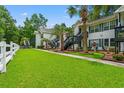 Charming condo exteriors surrounded by lush green lawns and mature palm trees at 820 Fairway Dr. # 1502Hh, Longs, SC 29568