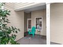 Cozy covered patio with a teal chair, small table, and a glimpse of the home's entrance at 100 Lazy Willow Ln. # 103, Myrtle Beach, SC 29588