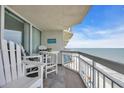 Relax on this inviting balcony with chairs and a table, enjoying ocean views and beach access in this beach themed condo at 1012 N Waccamaw Dr. # 1107, Murrells Inlet, SC 29576