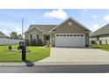 Charming single-story home with landscaped front yard and a spacious driveway leading to an attached garage at 1068 Lizzie Ln., Surfside Beach, SC 29575