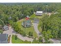 Aerial view of a charming home with a detached garage surrounded by lush greenery and mature trees at 124 Wicklow Way, Pawleys Island, SC 29585