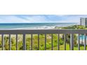 View from the condo balcony looking out to the beach, ocean, and grassy dunes with a glimpse of the pool at 145 South Dunes Dr. # 308, Pawleys Island, SC 29585