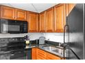 Efficient kitchen features black appliances, wood cabinets, and granite countertops at 1501 S Ocean Blvd. # 351, Myrtle Beach, SC 29577