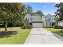 Charming two-story home with gray siding, brick accents, manicured landscaping, and a two-car garage at 1535 Harlow Ct., Myrtle Beach, SC 29579