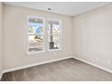 Neutral bedroom with plush carpet, white trim, and windows revealing the neighborhood outside at 1567 Breakwater Dr., Little River, SC 29566